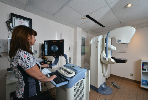 health care worker operating equipment used to perform a mammogram. 